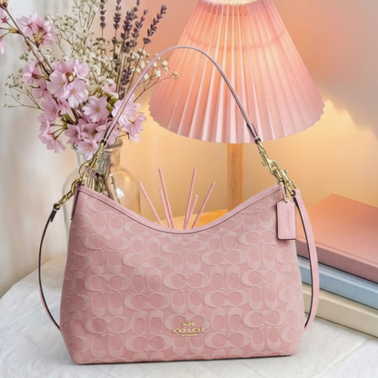 Coach pink embossed hobo bag on cozy background