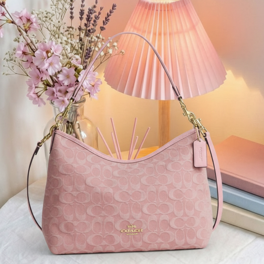 Coach pink embossed hobo bag on cozy background