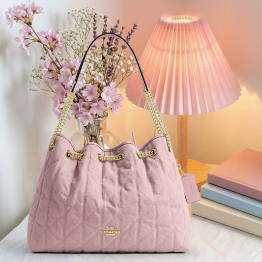 Coach pink quilted bag on cozy background