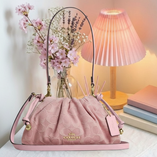 Coach pink ruched bag on cozy background